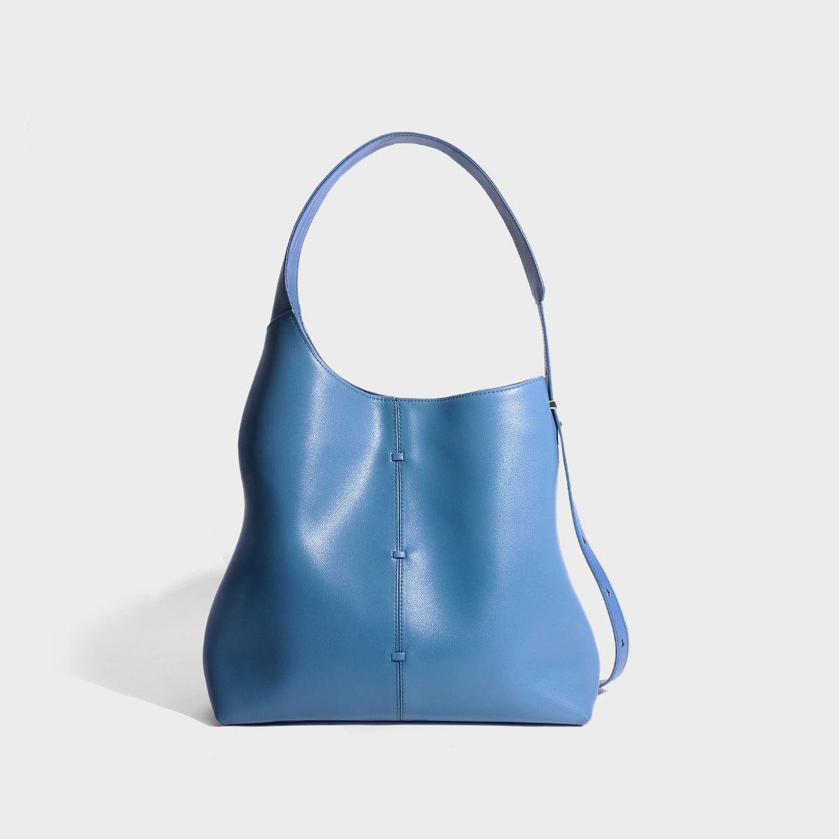 a blue handbag is sitting on a white surface5