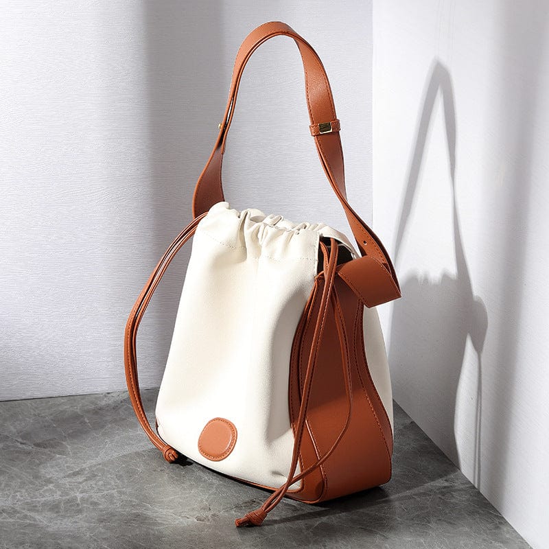 a white and brown handbag sitting on top of a table