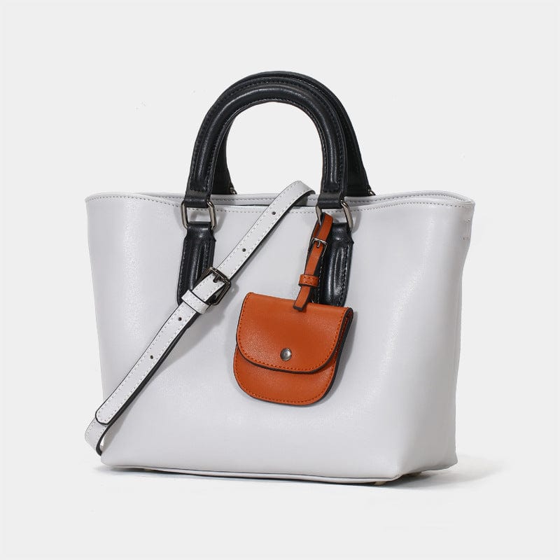 a white purse with a brown and black handle1